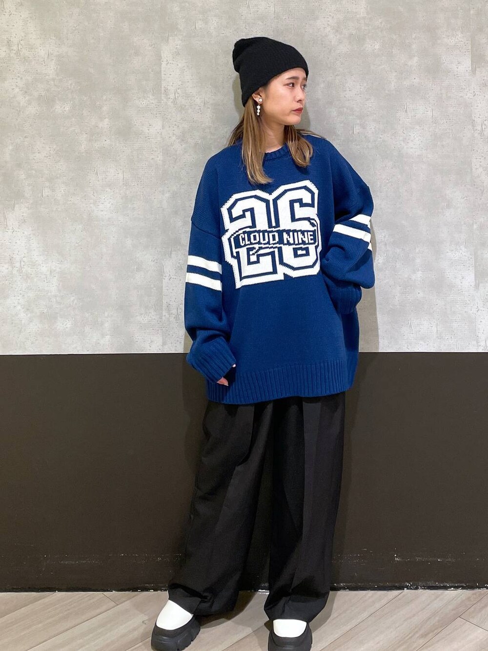 ホワイト系のブーツ、ブラック系のスラックス、ブルー系のニット/セーターを着用したレディースの秋コーディネートの4枚目の写真