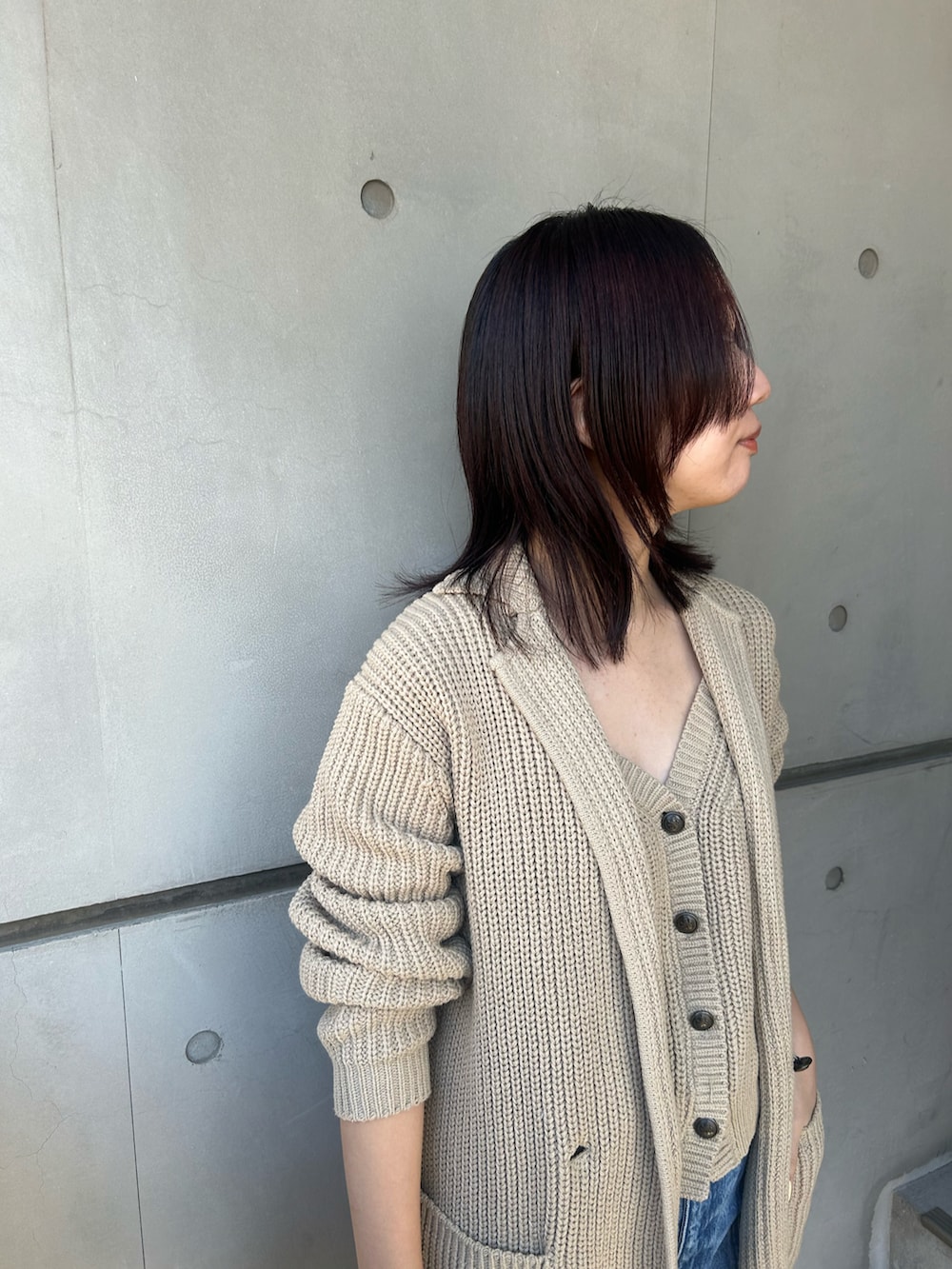 ベージュ系のベスト、ブルー系のチェスターコート、ブルー系のデニムパンツを着用したレディースの冬コーディネートの2枚目の写真