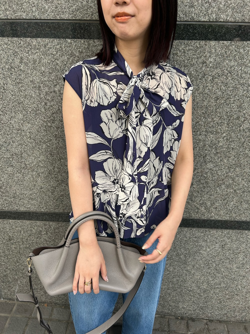 ブルー系のシャツ/ブラウス、ブルー系のデニムパンツ、グレー系のショルダーバッグを着用したレディースの夏コーディネートの2枚目の写真