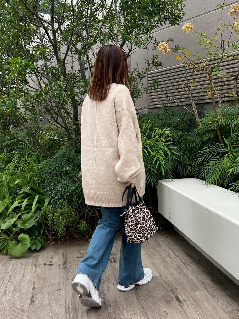 ベージュ系のカーディガン/ボレロ、ブルー系のデニムパンツを着用したレディースの秋コーディネートの2枚目の写真