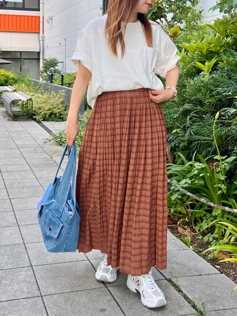 ブラウン系のスカート、ホワイト系のTシャツ/カットソーを着用したレディースの夏コーディネートの2枚目の写真