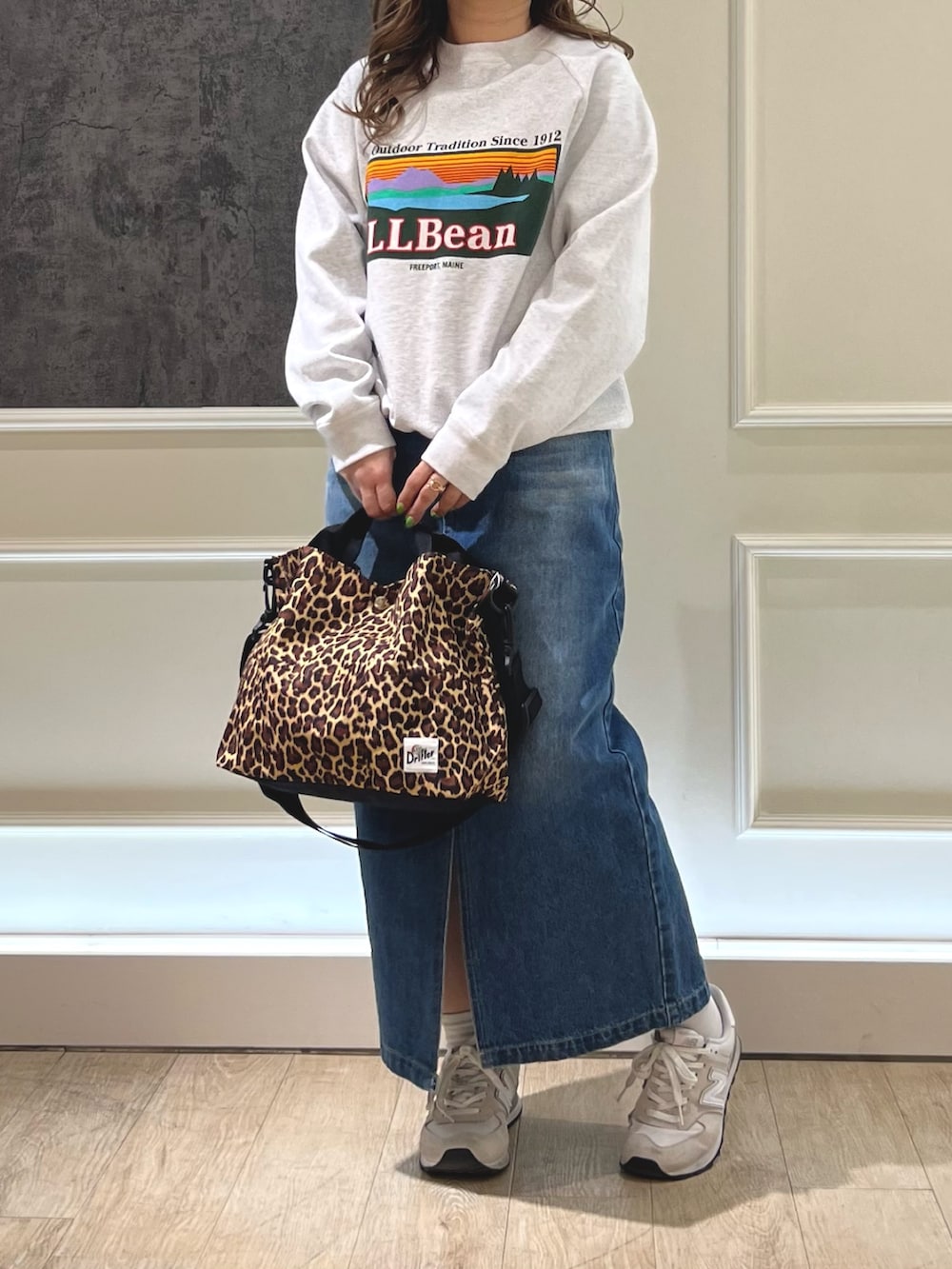 ブルー系のデニムスカート、グレー系のトップスを着用したレディースの冬コーディネートの2枚目の写真