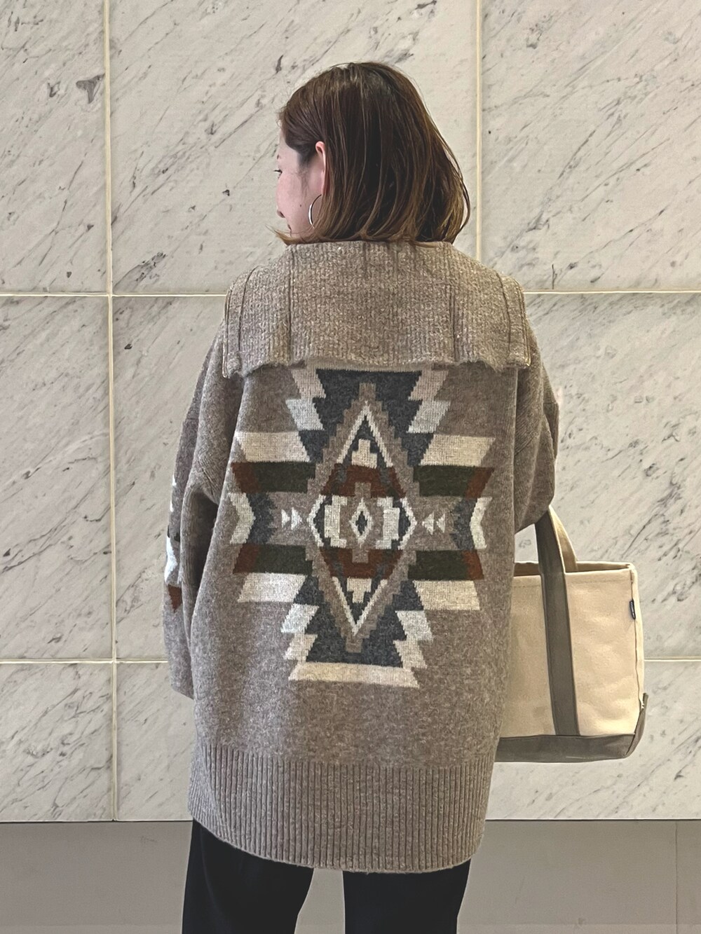 ブラック系のタンクトップ、ブラウン系のニット/セーター、グレー系のトートバッグを着用したレディースの秋コーディネートの2枚目の写真