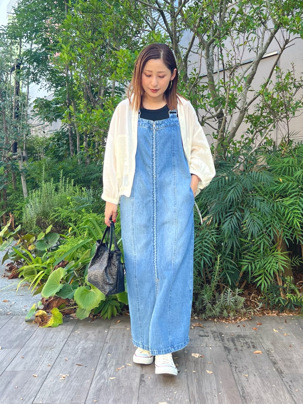 ホワイト系のスニーカー、ブルー系のワンピース、ホワイト系のジャケット/アウターを着用したレディースの秋コーディネートの2枚目の写真