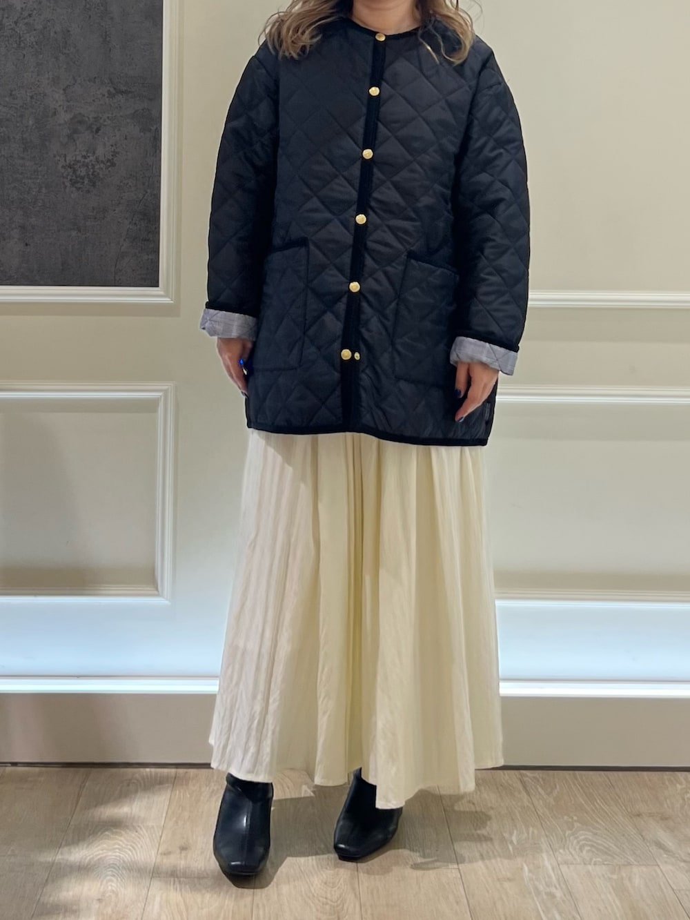 ホワイト系のスカート、ブラック系のブルゾンを着用したレディースの秋コーディネートの2枚目の写真