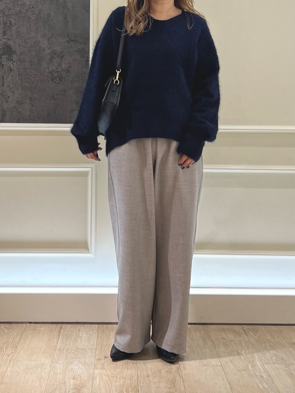 ブルー系のニット/セーター、ベージュ系のその他パンツ、ブラック系のショルダーバッグを着用したレディースの秋コーディネートの2枚目の写真