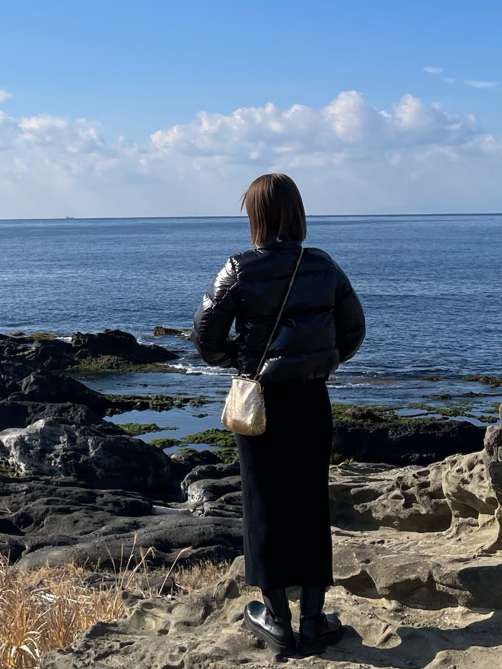 ブラック系のスカート、ブルー系のマフラーを着用したレディースの冬コーディネートの2枚目の写真