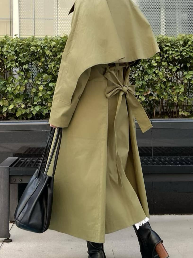 ブラック系のニット/セーター、ブラック系のブーツ、グリーン系のトレンチコートを着用したレディースの春コーディネートの3枚目の写真