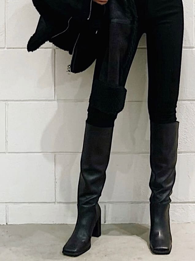 ブラック系のムートンコート、ブラック系のブーツ、ブラック系のデニムパンツを着用したレディースの冬コーディネートの4枚目の写真