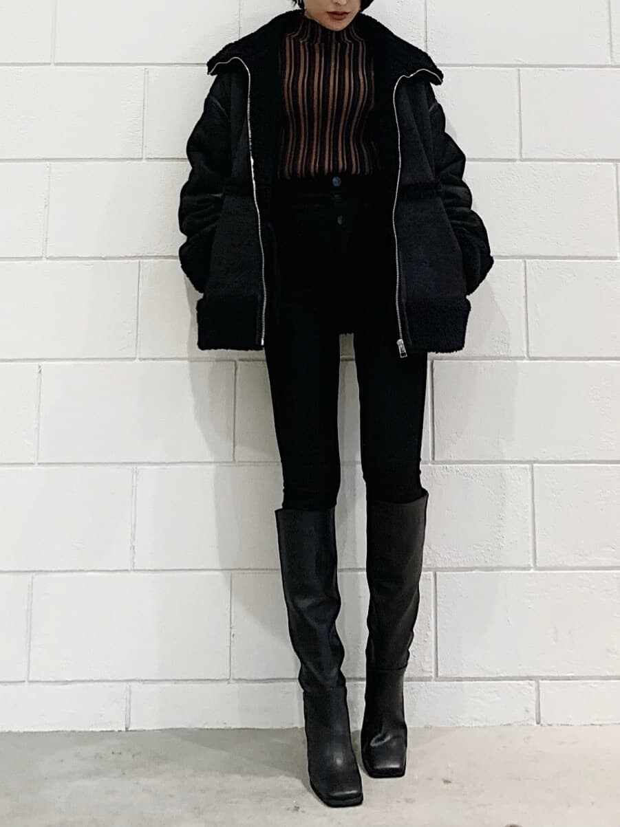 ブラック系のムートンコート、ブラック系のブーツ、ブラック系のデニムパンツを着用したレディースの冬コーディネートの3枚目の写真