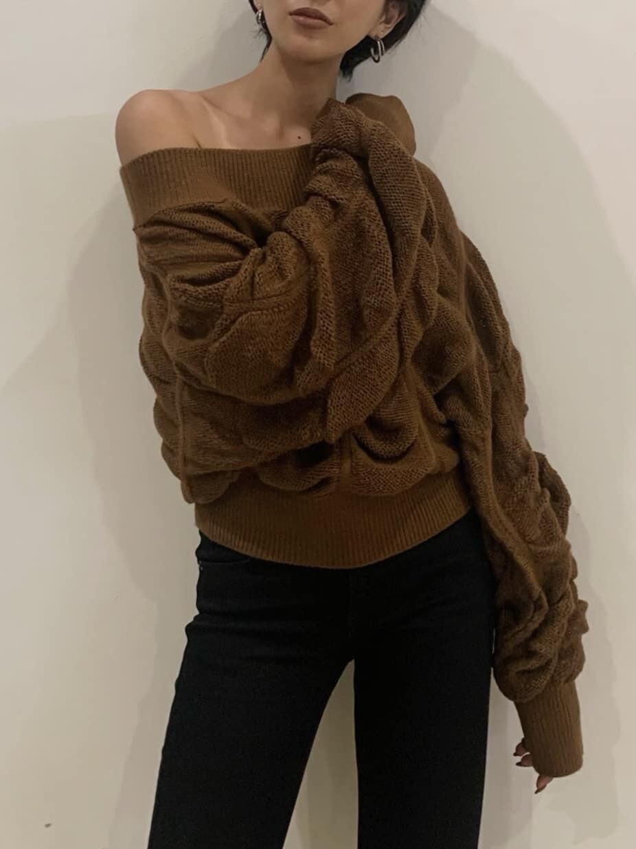 ブラック系のブーツ、ブラック系のデニムパンツ、ブラウン系のニット/セーターを着用したレディースの秋コーディネートの2枚目の写真