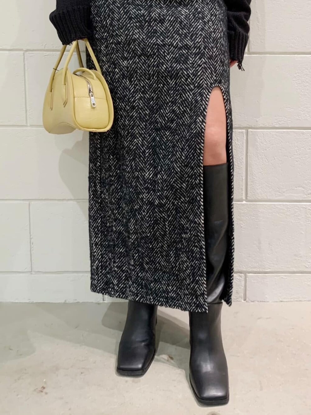ブラック系のニット/セーター、ブラック系のブーツ、ブラック系のスカートを着用したレディースの秋コーディネートの2枚目の写真