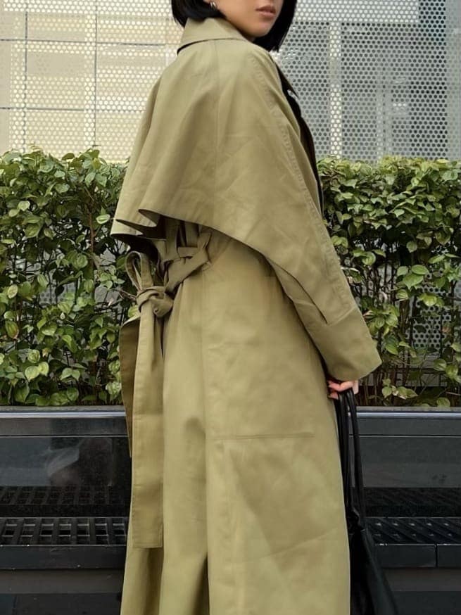 ブラック系のニット/セーター、ブラック系のブーツ、グリーン系のトレンチコートを着用したレディースの春コーディネートの4枚目の写真