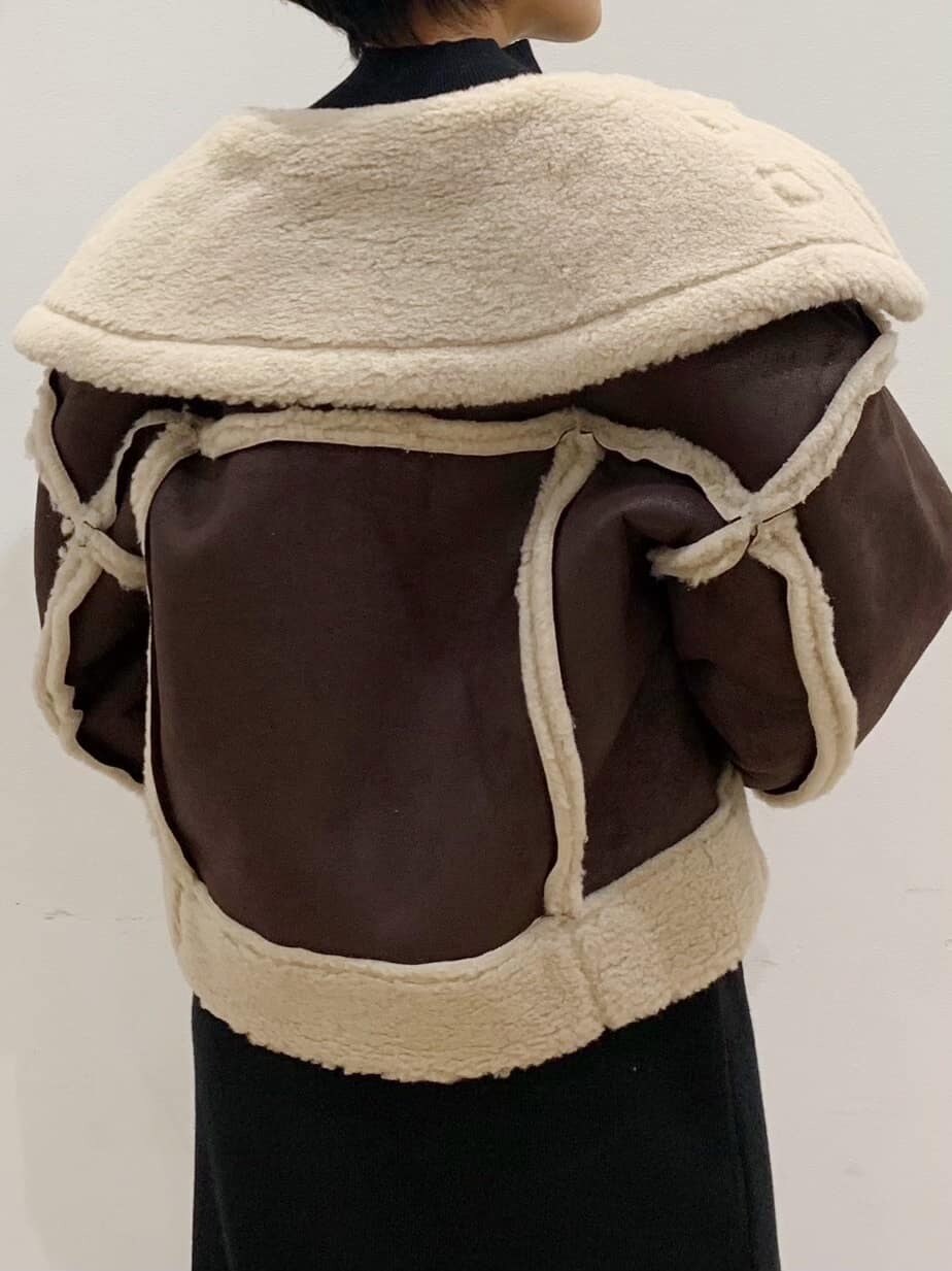 ブラウン系のブーツ、その他のムートンコートを着用したレディースの秋コーディネートの3枚目の写真