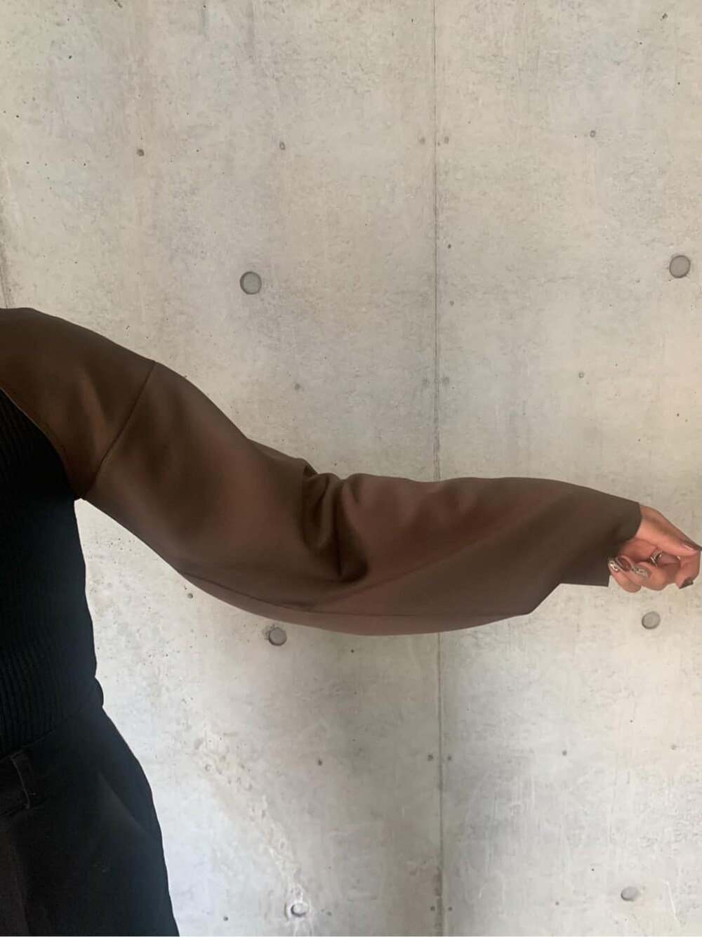 ブラック系のブーツ、ブラック系のニット/セーター、ブラウン系のTシャツ/カットソーを着用したレディースの秋コーディネートの4枚目の写真