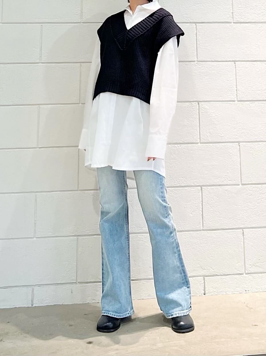 ブラック系のベスト、ブラック系のブーツ、ブルー系のデニムパンツを着用したレディースの春コーディネートの3枚目の写真