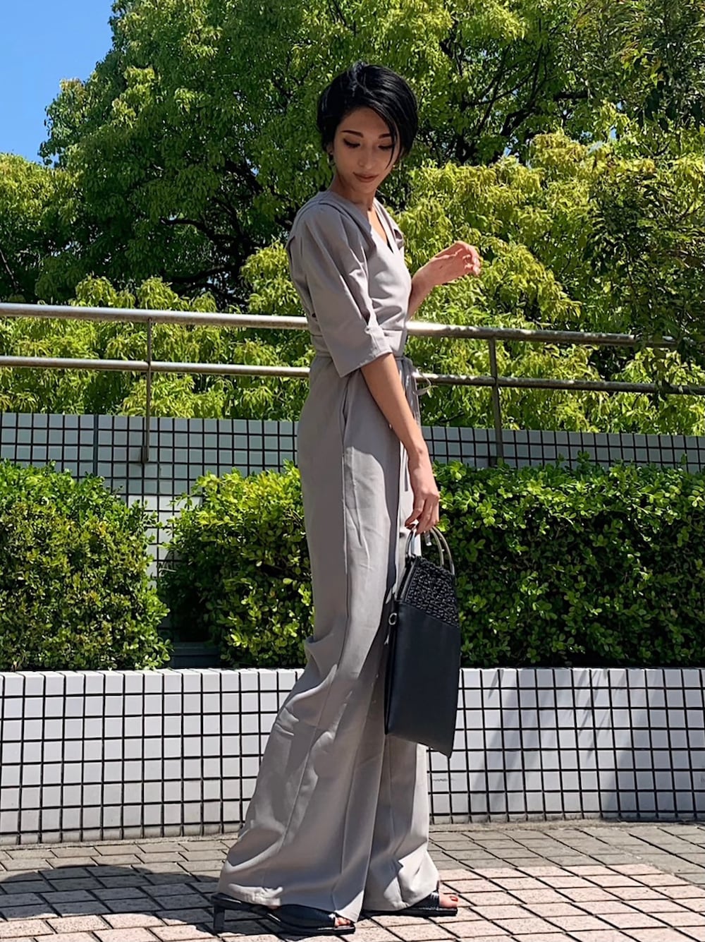 グレー系のつなぎ/オールインワン、ブラック系のサンダルを着用したレディースの春コーディネートの2枚目の写真