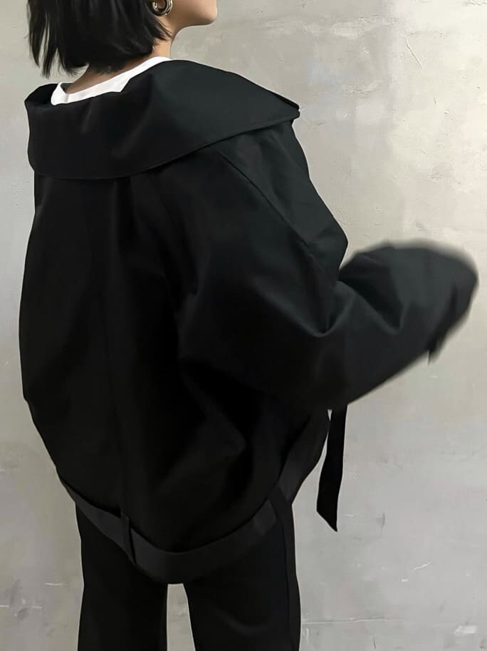 ブラック系のトレンチコート、ブラック系のその他パンツ、ブルー系のハンドバッグを着用したレディースの冬コーディネートの2枚目の写真