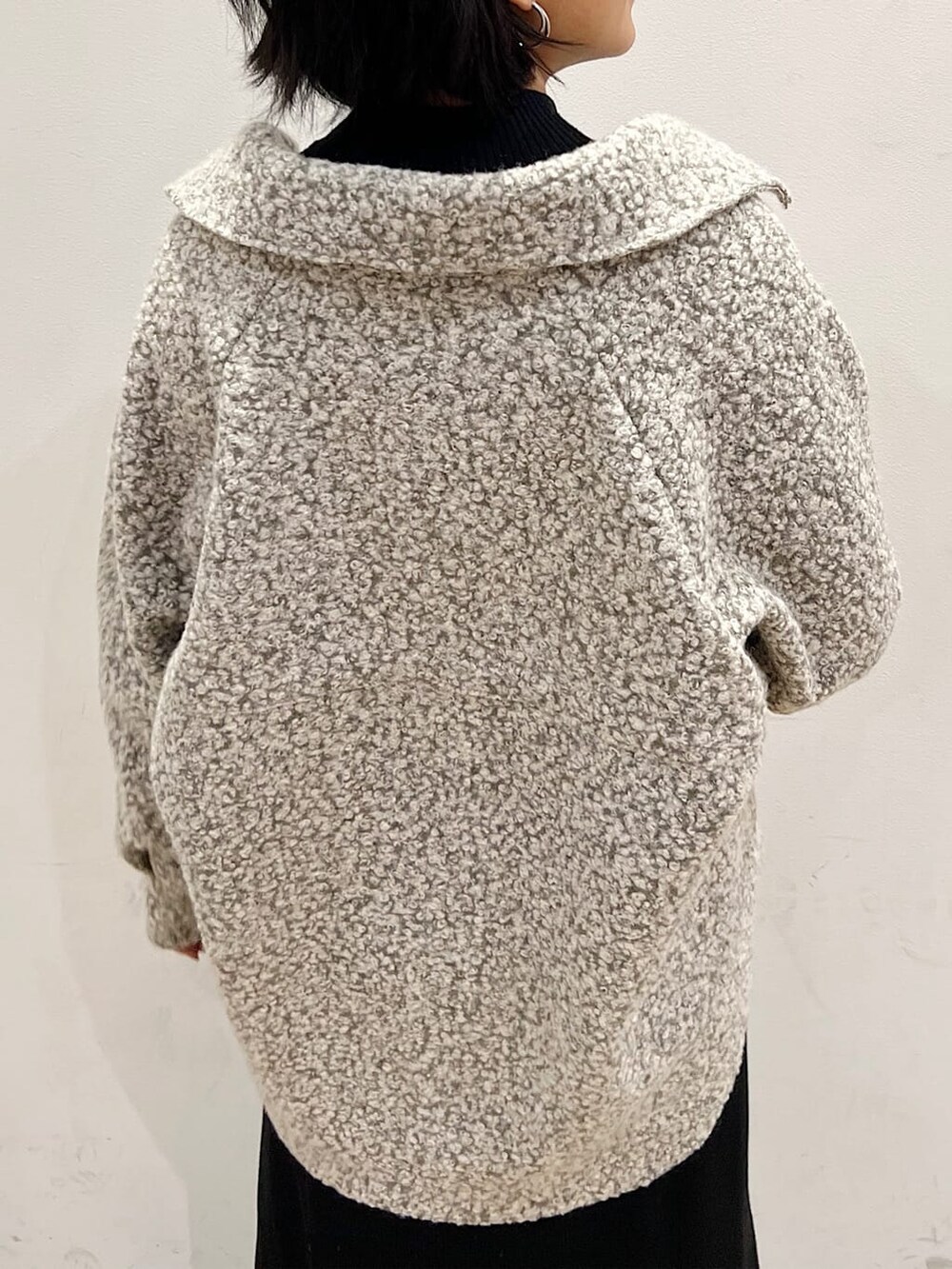 ブラック系のワンピース、ブラック系のブーツ、グレー系のブルゾンを着用したレディースの冬コーディネートの3枚目の写真