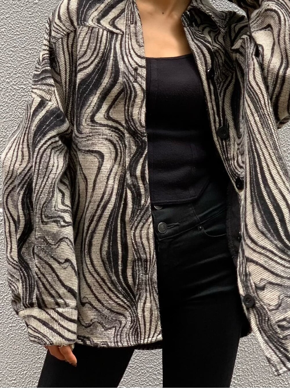 ブラック系のタンクトップ、ブラック系のデニムパンツ、その他のブルゾンを着用したレディースの秋コーディネートの2枚目の写真