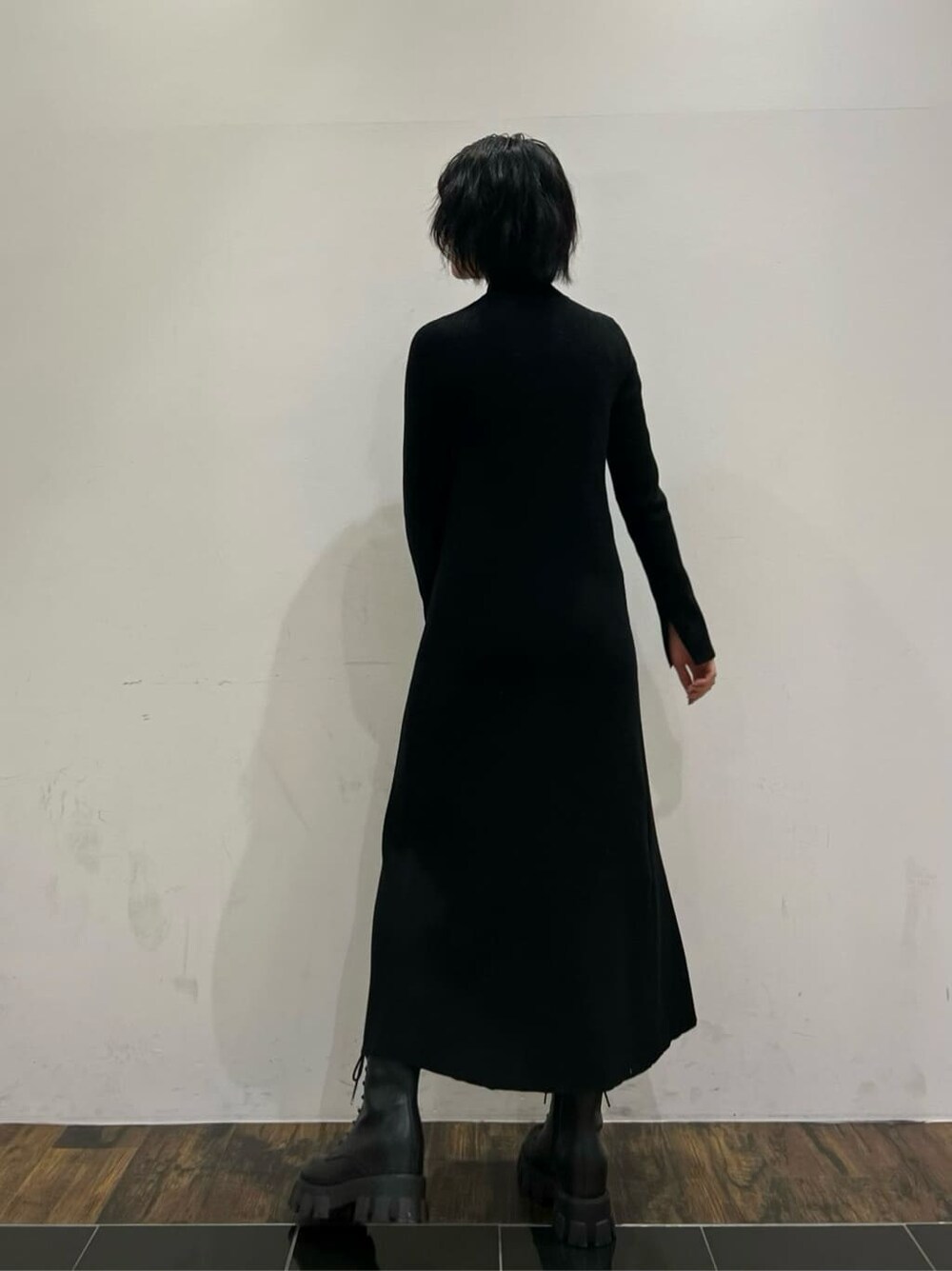 ブラック系のワンピース、ブラック系のブーツ、グレー系のブルゾンを着用したレディースの冬コーディネートの4枚目の写真