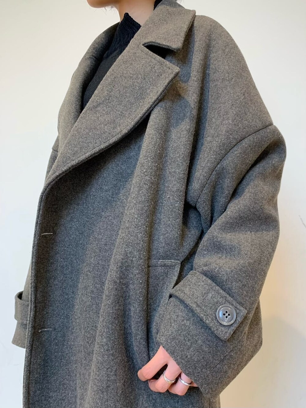 ブラック系のブーツ、ブルー系のデニムパンツ、グレー系のチェスターコートを着用したレディースの秋コーディネートの2枚目の写真