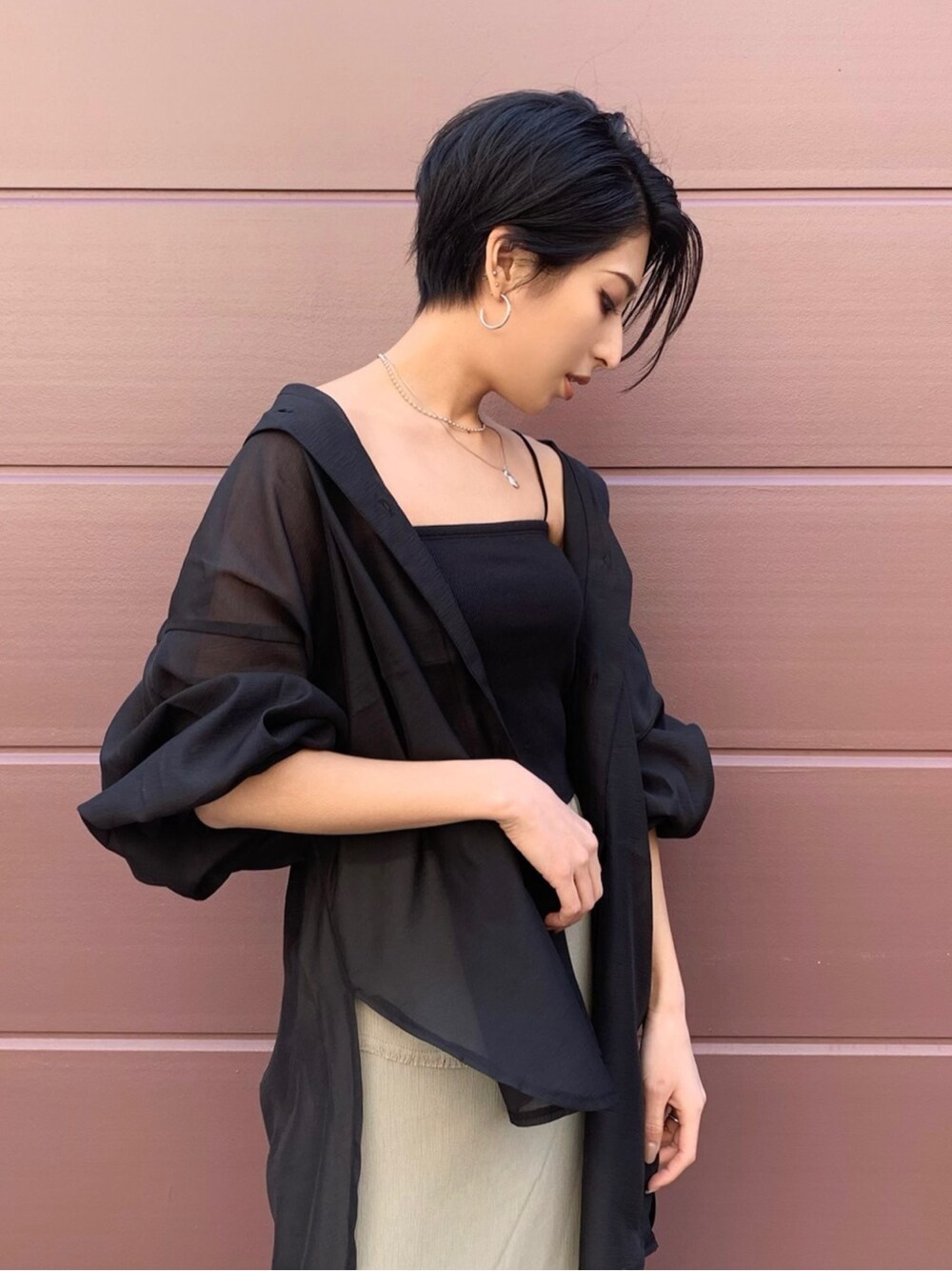 ブラック系のシャツ/ブラウス、ベージュ系のスカート、ブラック系のサンダルを着用したレディースの春コーディネートの3枚目の写真