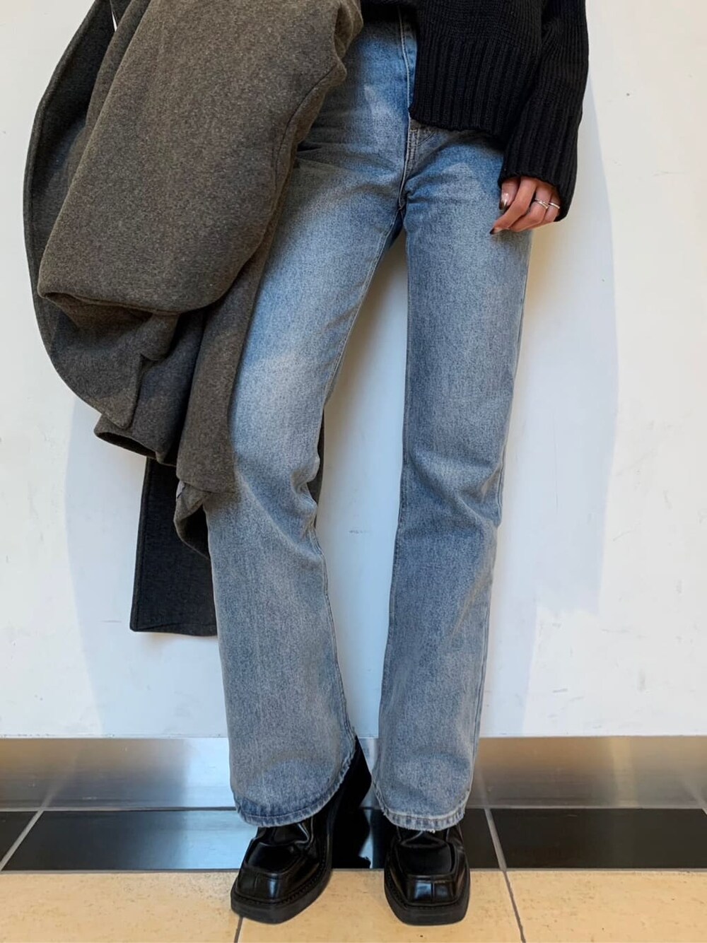 ブラック系のブーツ、ブルー系のデニムパンツ、グレー系のチェスターコートを着用したレディースの秋コーディネートの6枚目の写真