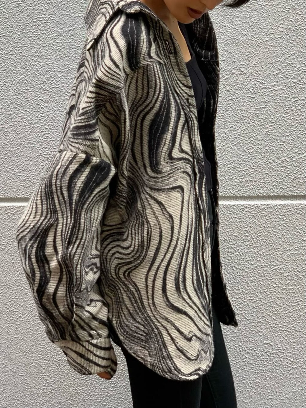 ブラック系のタンクトップ、ブラック系のデニムパンツ、その他のブルゾンを着用したレディースの秋コーディネートの3枚目の写真