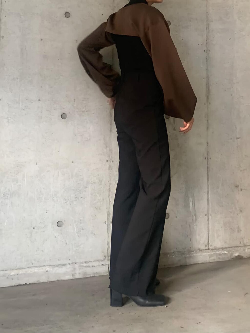 ブラック系のブーツ、ブラック系のニット/セーター、ブラウン系のTシャツ/カットソーを着用したレディースの秋コーディネートの2枚目の写真