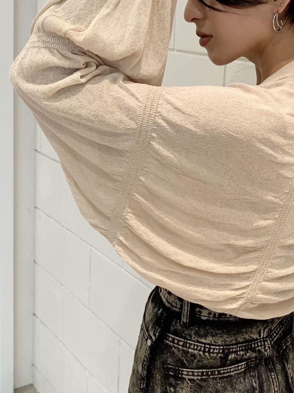 ブラック系のパンプス、ブラウン系のデニムパンツ、ベージュ系のカーディガン/ボレロを着用したレディースの秋コーディネートの2枚目の写真