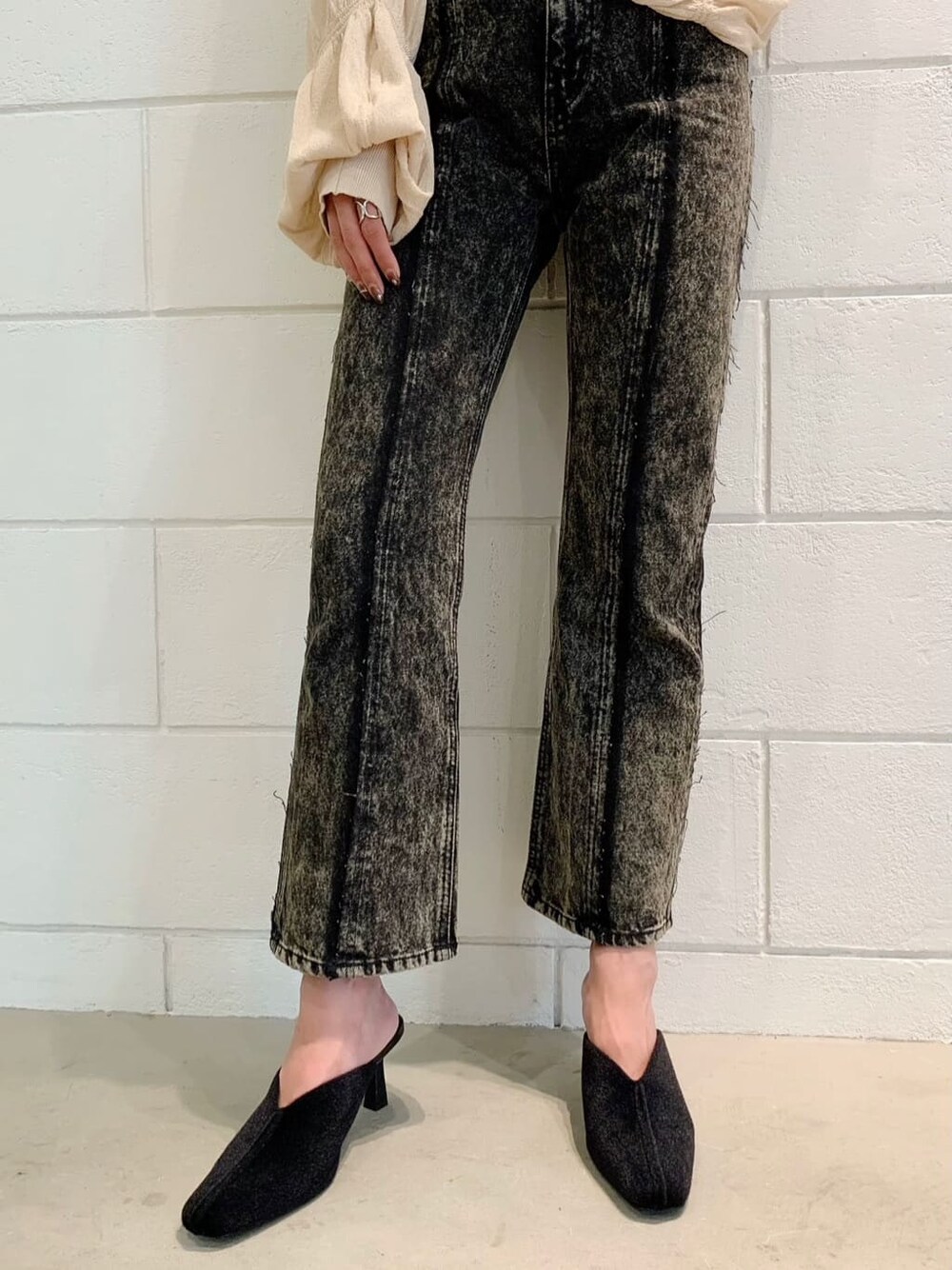 ブラック系のパンプス、ブラウン系のデニムパンツ、ベージュ系のカーディガン/ボレロを着用したレディースの秋コーディネートの3枚目の写真