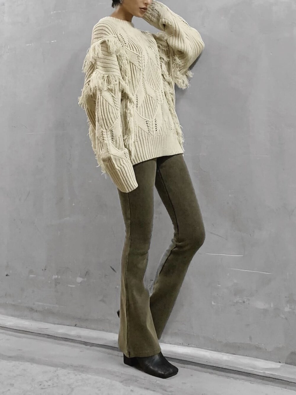 ブラック系のブーツ、ベージュ系のその他パンツ、ホワイト系のニット/セーターを着用したレディースの秋コーディネートの3枚目の写真