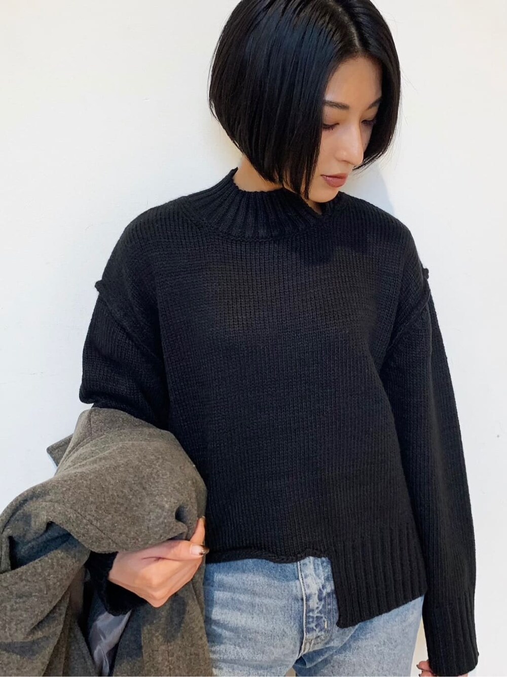 ブラック系のブーツ、ブルー系のデニムパンツ、グレー系のチェスターコートを着用したレディースの秋コーディネートの4枚目の写真