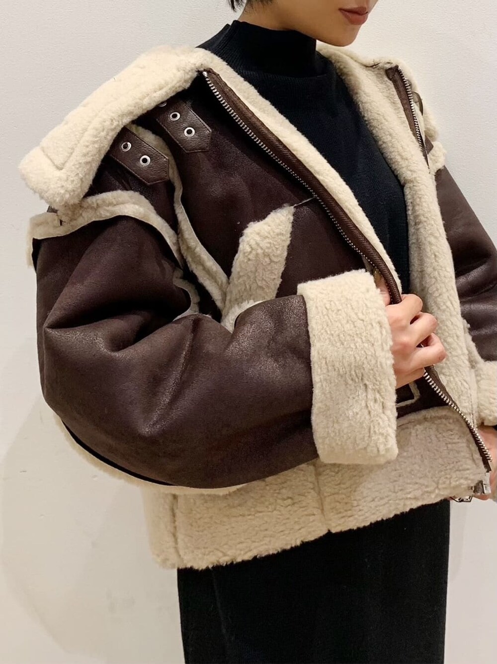 ブラウン系のブーツ、その他のムートンコートを着用したレディースの秋コーディネートの4枚目の写真