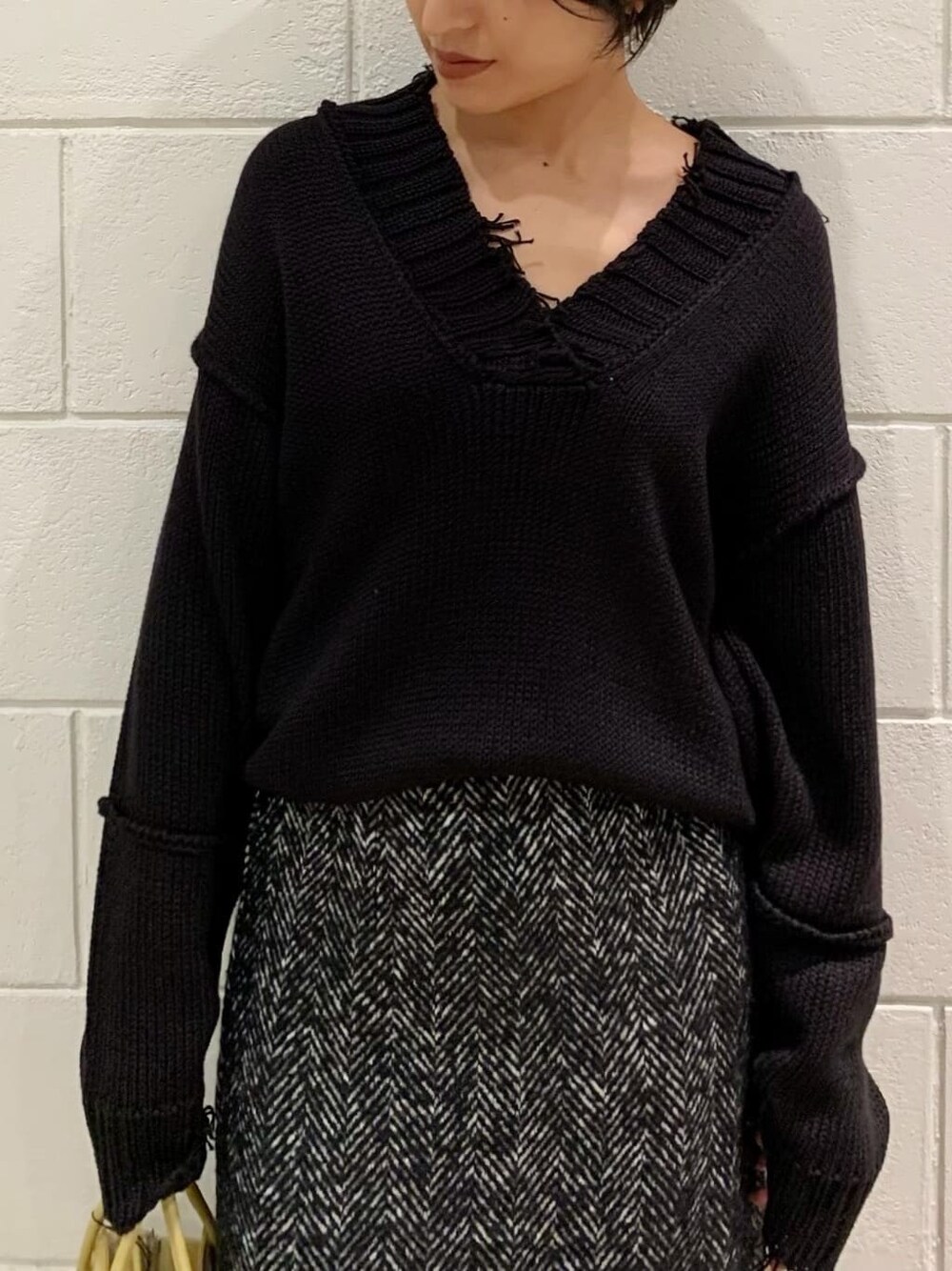 ブラック系のニット/セーター、ブラック系のブーツ、ブラック系のスカートを着用したレディースの秋コーディネートの3枚目の写真