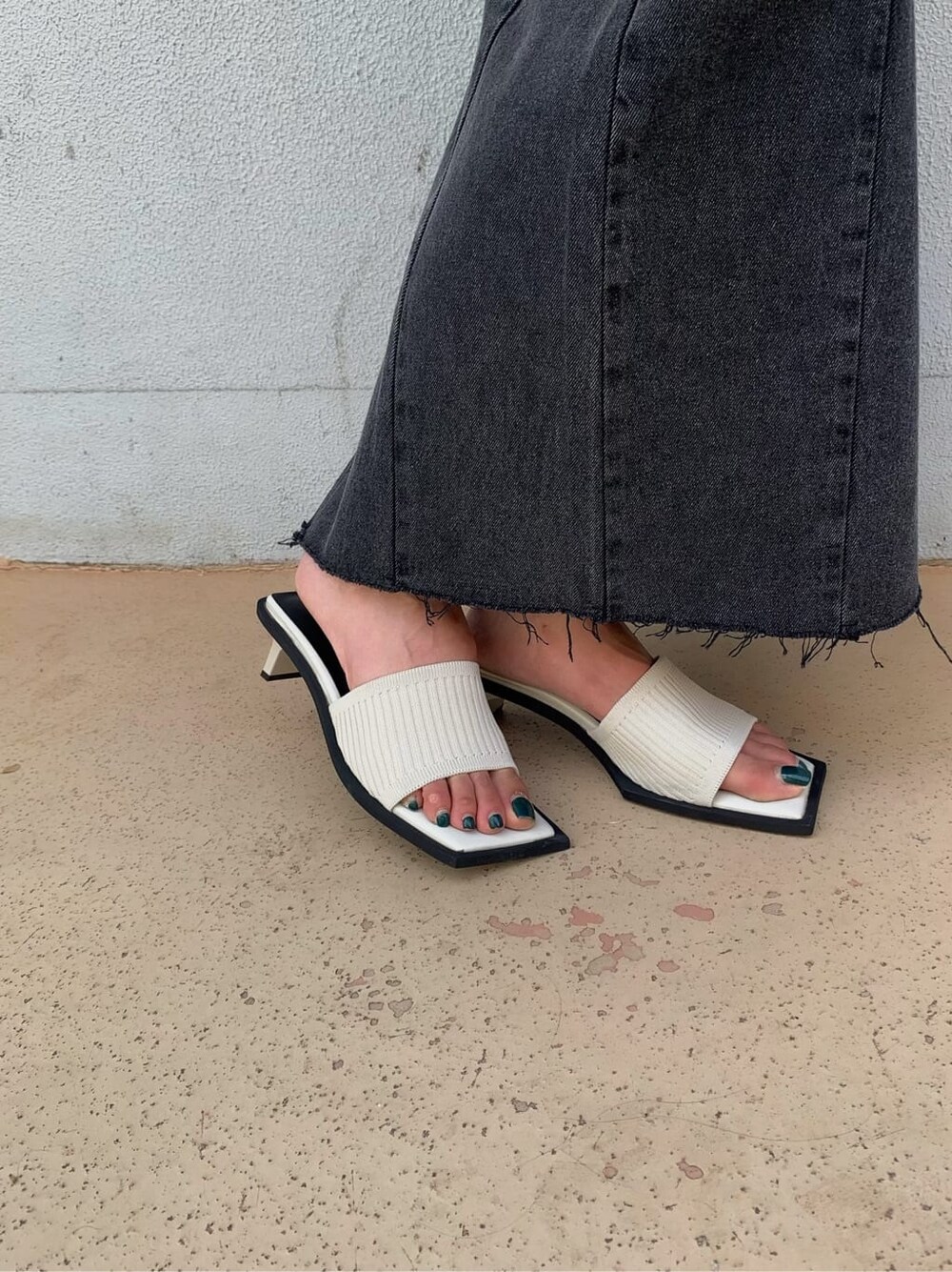 ブラック系のデニムスカート、ホワイト系のサンダル、ホワイト系のTシャツ/カットソーを着用したレディースの夏コーディネートの4枚目の写真