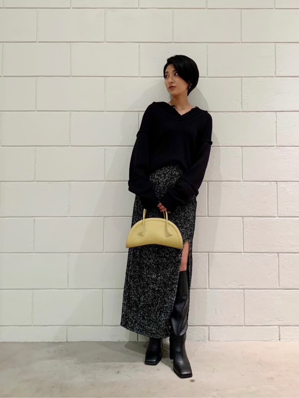 ブラック系のニット/セーター、ブラック系のブーツ、ブラック系のスカートを着用したレディースの秋コーディネートの4枚目の写真