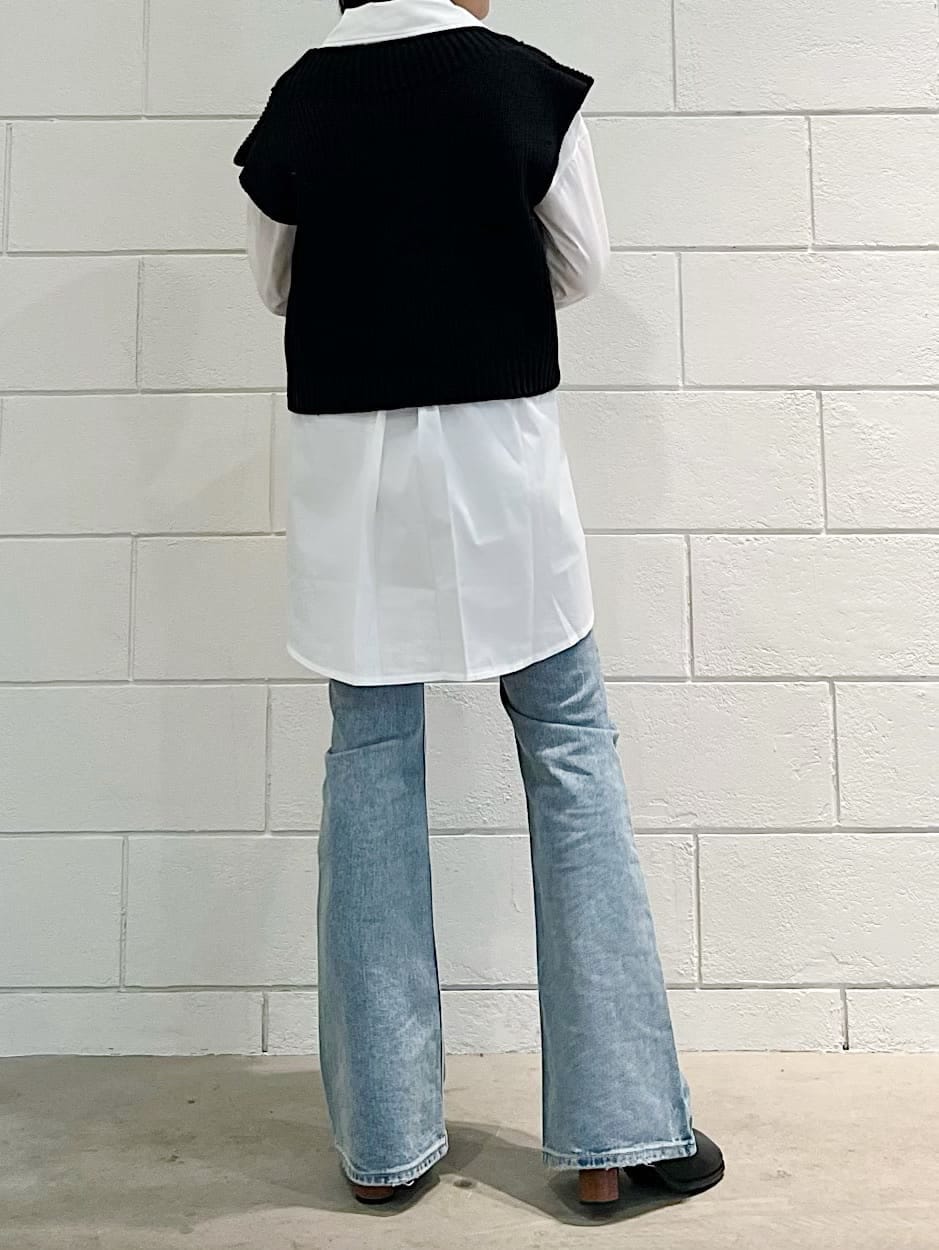 ブラック系のベスト、ブラック系のブーツ、ブルー系のデニムパンツを着用したレディースの春コーディネートの2枚目の写真