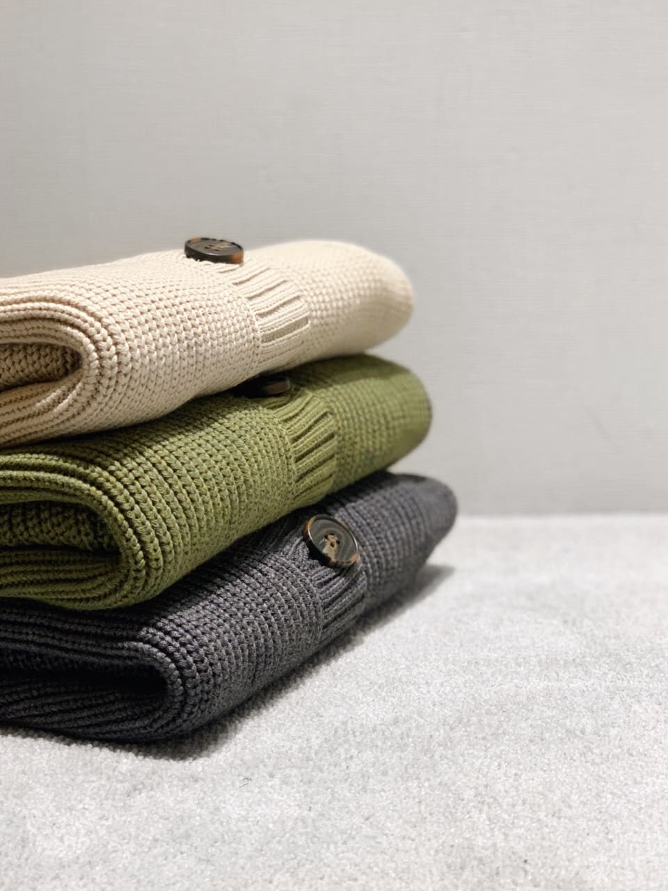 ブラック系のデニムパンツ、ブラック系のブーツ、グレー系のカーディガン/ボレロを着用したレディースの秋コーディネートの2枚目の写真