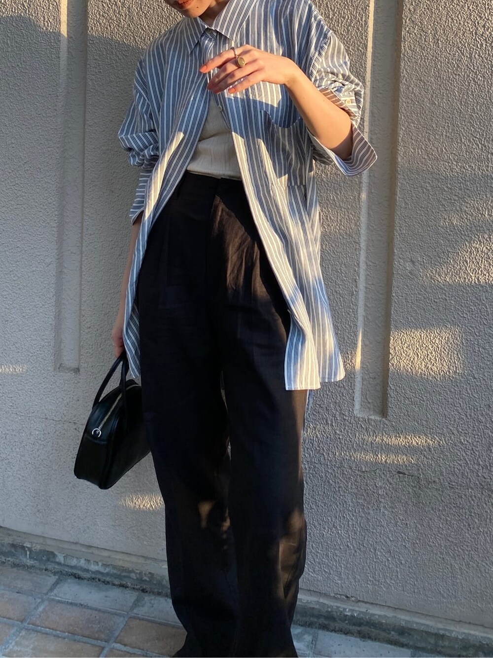 ブルー系のシャツ/ブラウス、ブラック系のその他パンツ、ブラック系のハンドバッグを着用したレディースの春コーディネートの5枚目の写真