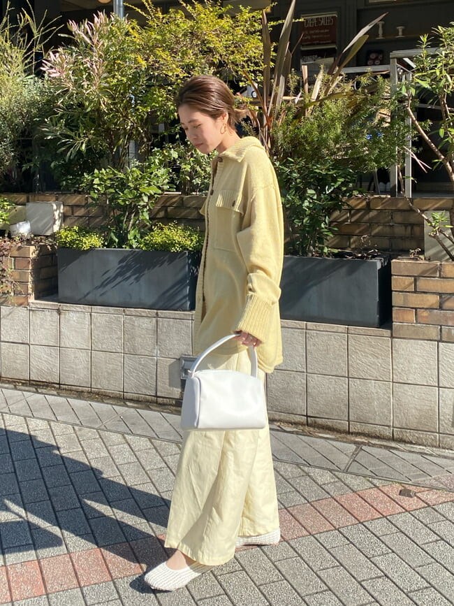ホワイト系のパンプス、イエロー系のカーディガン/ボレロ、イエロー系のスラックスを着用したレディースの冬コーディネートの2枚目の写真