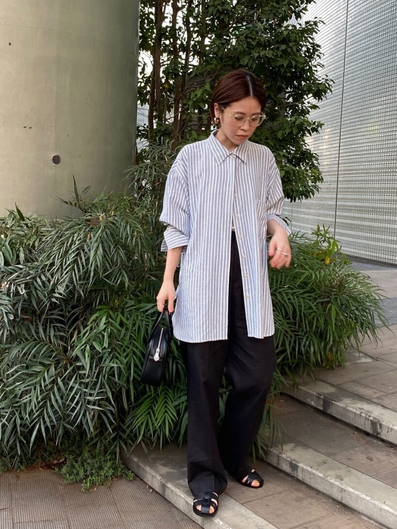 ブルー系のシャツ/ブラウス、ブラック系のその他パンツ、ブラック系のハンドバッグを着用したレディースの春コーディネートの2枚目の写真