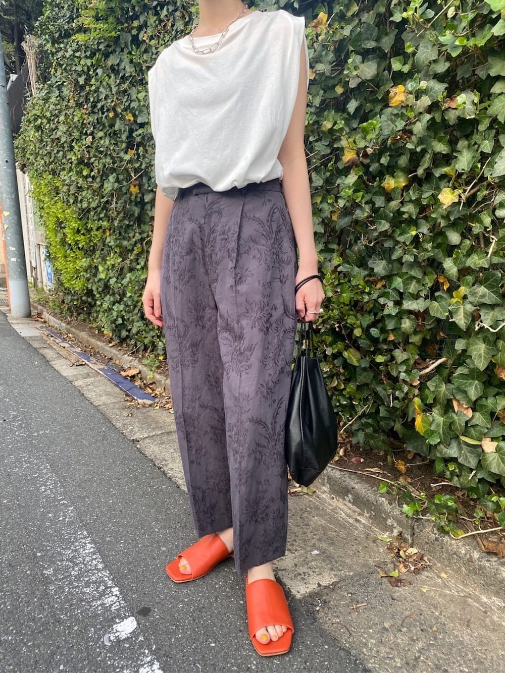 グレー系のその他パンツ、オレンジ系のサンダルを着用したレディースの春コーディネートの2枚目の写真