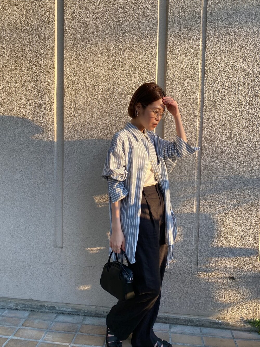 ブルー系のシャツ/ブラウス、ブラック系のその他パンツ、ブラック系のハンドバッグを着用したレディースの春コーディネートの3枚目の写真