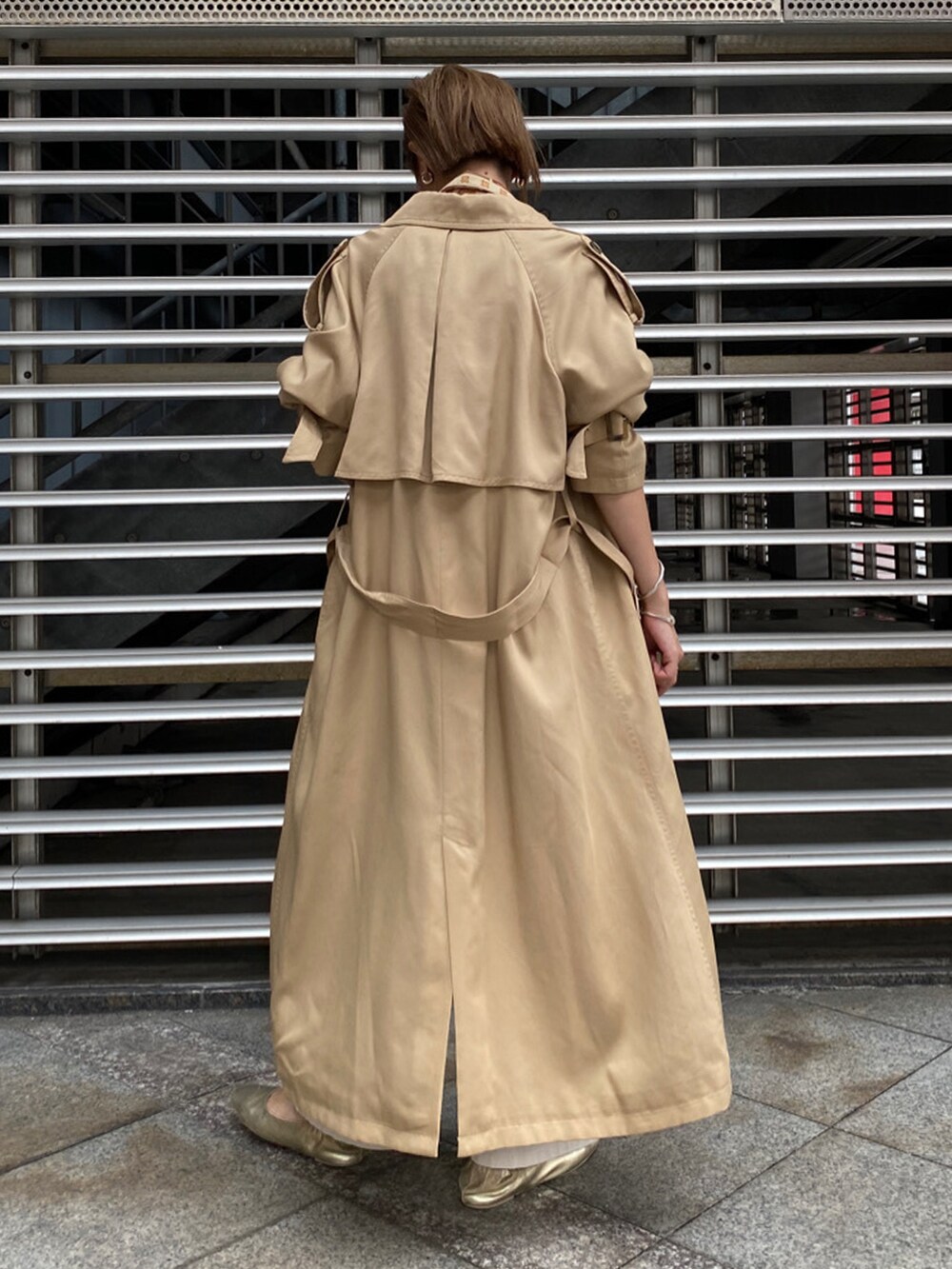 ベージュ系のトレンチコート、ベージュ系のシャツ/ブラウス、ホワイト系のその他パンツを着用したレディースの秋コーディネートの3枚目の写真