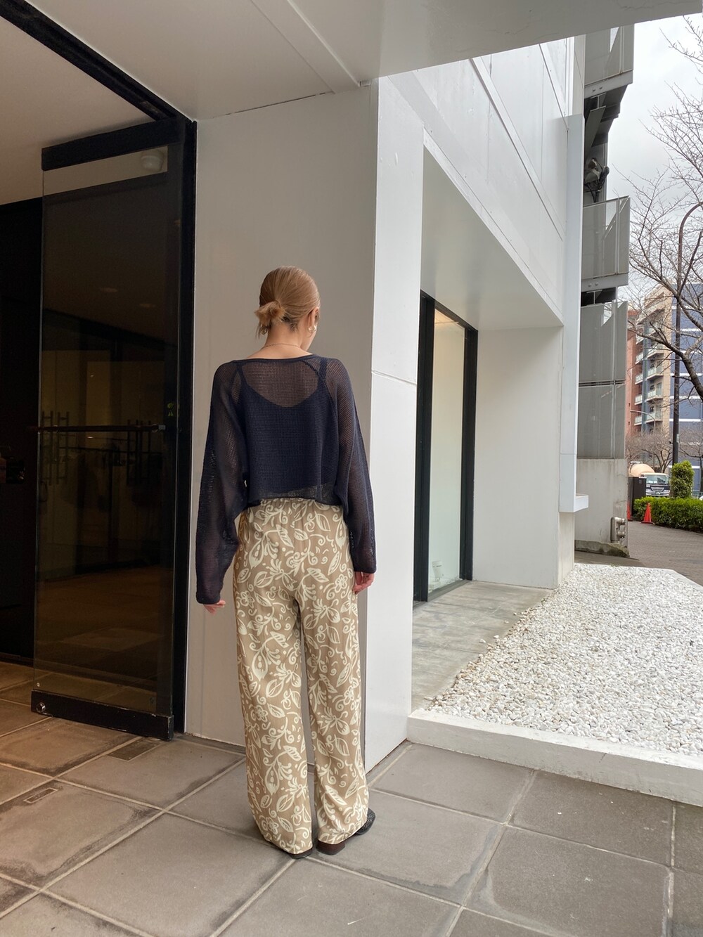 ベージュ系のその他パンツ、ホワイト系のTシャツ/カットソー、ブラック系のサンダルを着用したレディースの春コーディネートの2枚目の写真