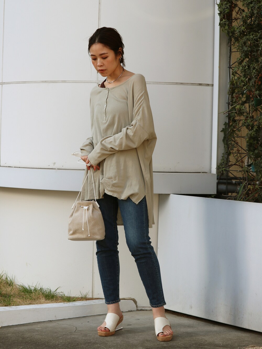 ブルー系のデニムパンツ、グリーン系のTシャツ/カットソーを着用したレディースの春コーディネートの2枚目の写真
