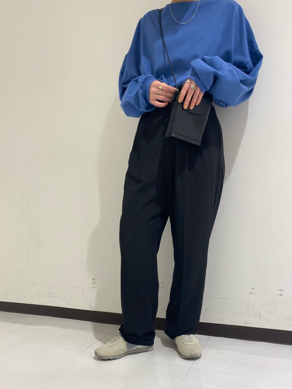 ブラック系のスラックス、ブルー系のTシャツ/カットソーを着用したレディースの冬コーディネートの3枚目の写真