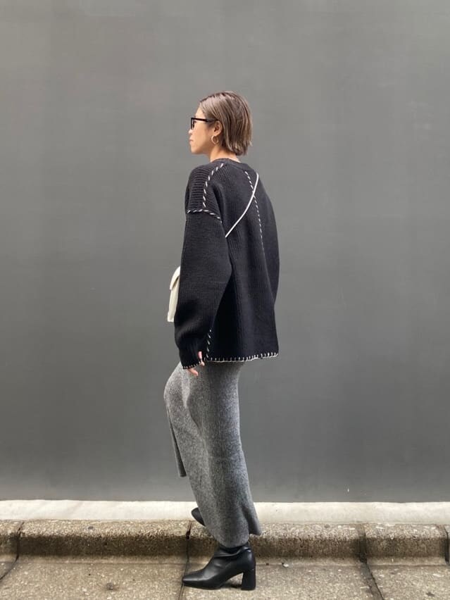 グレー系のスカート、ブラック系のニット/セーターを着用したレディースの冬コーディネートの2枚目の写真